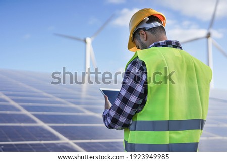 Man working at solar power station with digital tablet 