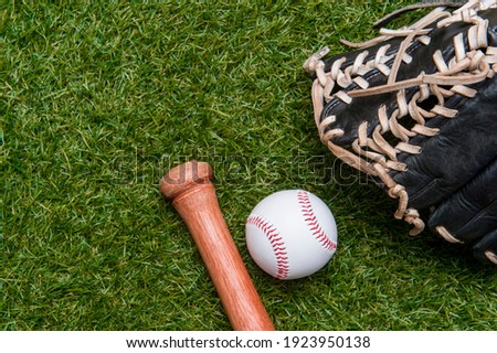 Baseball bat, glove and ball on green grass field.  Sport theme background with copy space for text and advertisment