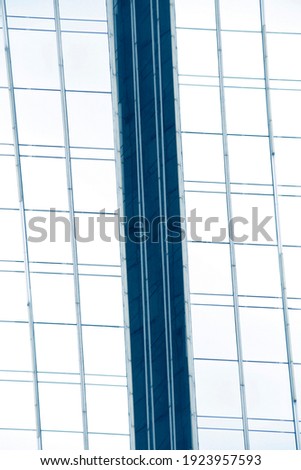 Fragment of glass and metal facade walls. Exterior of commerical real estate office building. Abstract modern business architecture. Regular background with checkered structure of rectangular panels.