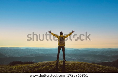 Hiker with arms up standing on the top of the mountain - Successful man enjoying triumph - Sport and success concept Royalty-Free Stock Photo #1923965951