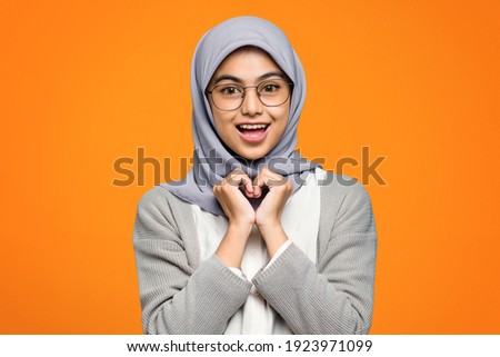Beautiful Asian woman cheerful wearing eyeglass on orange background