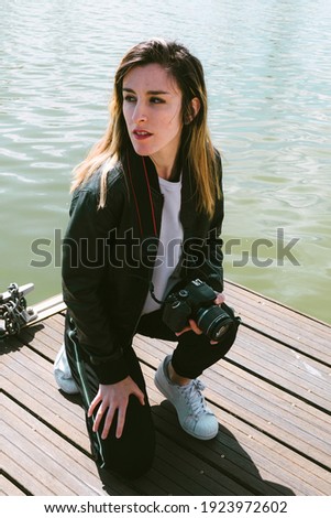 Stock photo taken of a woman carrying a camera and observing from the jetty which is the best perspective to take a photo