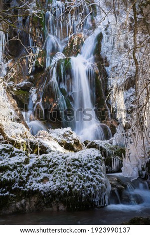 Winter waterfall snow scene. Snowy mountain waterfall landscape.