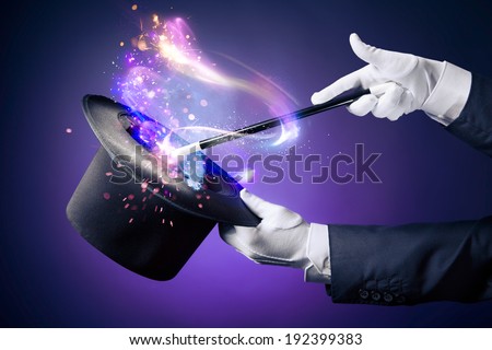 Magician hand with magic wand and hat Royalty-Free Stock Photo #192399383