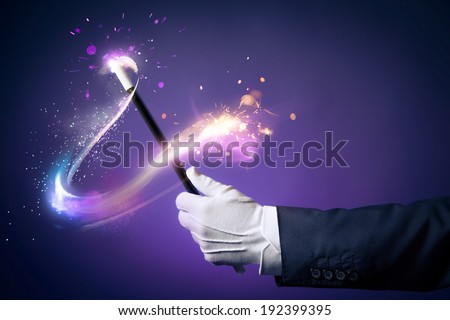 Magician hand with magic wand Royalty-Free Stock Photo #192399395