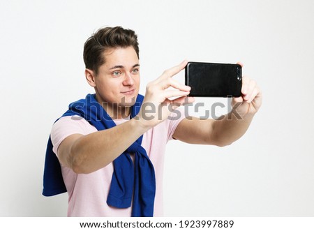 Handsome caucasian man taking a self portrait over white background