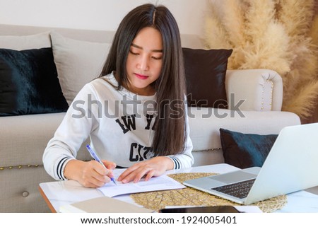 social distancing student concept, Junior high school girl and boy Do homework at home with laptop. education at home. the school is closed during Covid-19 asia Thailand