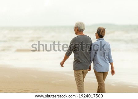Asia Lifestyle senior couple walking chill on the beach happy in love romantic and relax time.  People tourism elderly family travel leisure and activity after retirement in vacations and summer. Royalty-Free Stock Photo #1924017500
