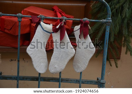 Merry Xmas text invitation card. Hanging Christmas socks on gradient gray beige background. Colorful stocking decoration