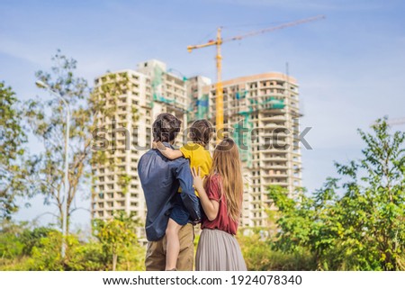 Family mother, father and son looking at their new house under construction, planning future and dreaming. Young family dreaming about a new home. Real estate concept Royalty-Free Stock Photo #1924078340