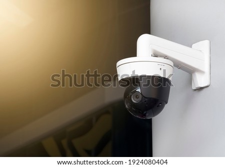 Modern public CCTV camera on wall with blur building background. Recording cameras for monitoring all day and night. Concept of surveillance and monitoring with copy space. Royalty-Free Stock Photo #1924080404