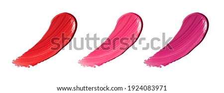 Collection of three colors of smudged lipstick on a white background