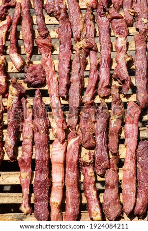 Image of red meat getting dried with the sun. Asian food, traditional way to preserve meat.