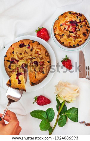 Delicious fruit pie from an air dough, tasty summer dessert, on a white wooden background, top view.