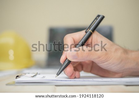Hand hold pen writing on document Royalty-Free Stock Photo #1924118120