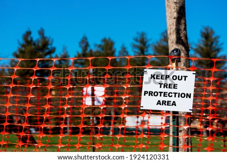 Keep out, Tree protection area sign on orange tree protection plastic mesh fencing.
