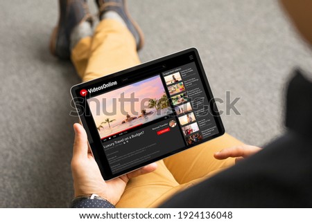 Man watching videos online on tablet Royalty-Free Stock Photo #1924136048