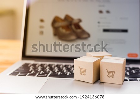 Online shopping - Paper cartons or parcel with a shopping cart logo on a laptop keyboard which web store shop on screen, Shopping service on The online web and offers home delivery.