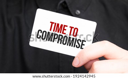 Businessman holding a card with text Time to compromise,business concept