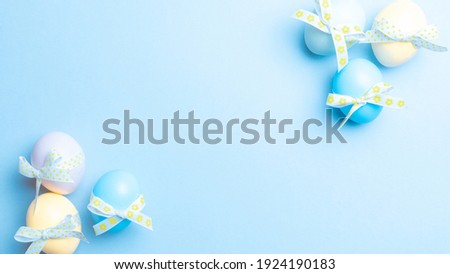 Easter banner. Colourful egg with tape ribbon on pastel blue background in Happy Easter decoration. Foil minimalist egg design, modern top view template