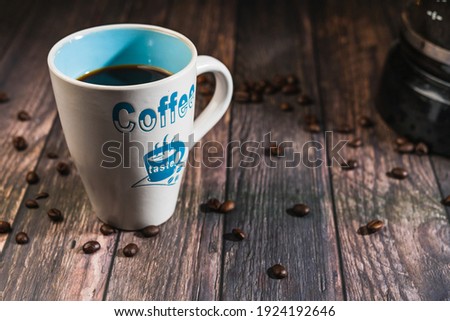 coffee in white cup on wooden background coffee beans placed around