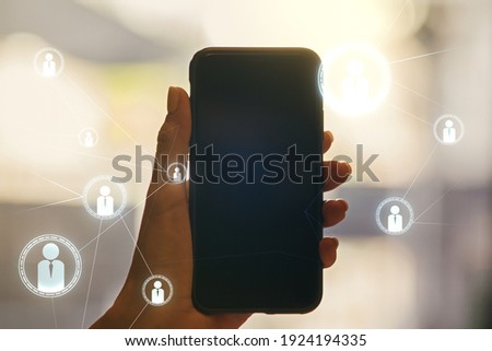 Double exposure of social network icons concept and hand with cellphone on background. Networking concept