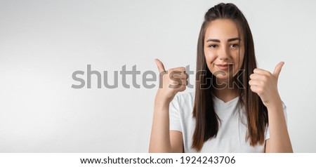 Good job. Pretty carefree modern stylish European girl with long chestnut hair making OK with both hands, gesture as if saying that everything is finee, white background. Copy space for your text