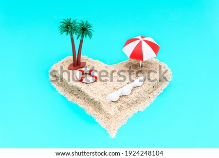 Angle view of a heart-shaped miniature toy island composition with palm trees, sun umbrella, a lifebuoy and seashells on a light blue background imitating the ocean. Romantic vacation concept.