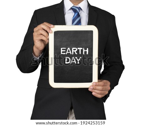 A Businessman holding slate mini blackboard with message Earth Day