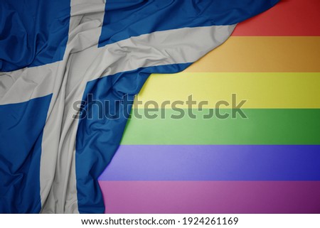 waving colorful national flag of scotland on a gay rainbow flag background.