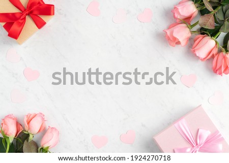 Giftbox and pink rose flower on marble white table background for Mother's Day holiday greeting design concept.