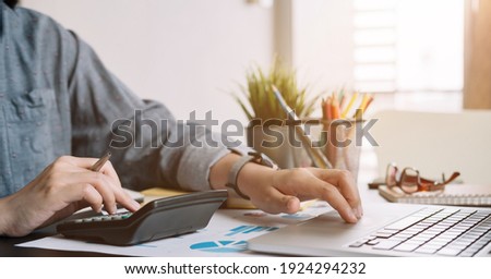 Close up businessman or accountant working using calculator with financial report and calculator
