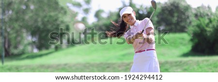 Woman golfer with golf club in hand and flying ball after hitting. Sports and golf concept
