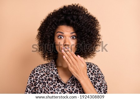 Photo portrait of curly woman closed mouth with hand staring in stylish outfit isolated pastel beige color background