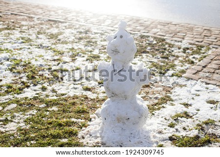 A ridiculous snowman standing on green grass in a sunny day. Outdoor leisure activities to do with children. Stock photography.