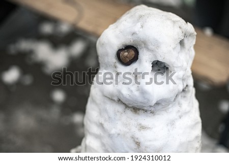 A ridiculous snowman made of dirty snow. Outdoor leisure activities to do with children. Stock photography.