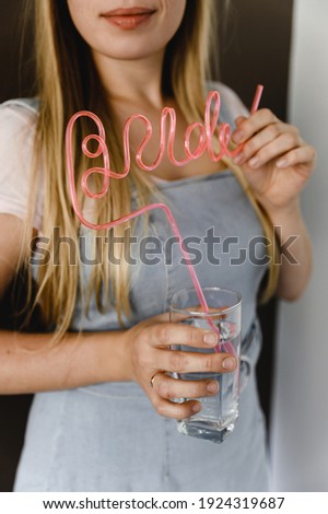 girl holding a straw for drinking water in her hands. girl drinks water through an ecological straw. bachelorette party details. accessories for the holiday.