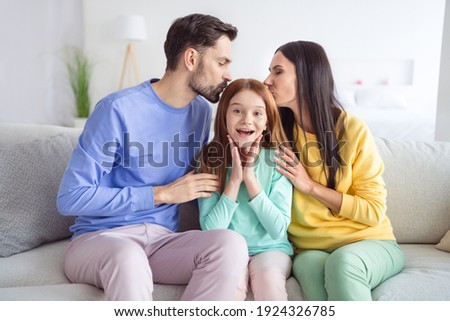 Photo portrait of parents kissing daughter spending time together at home