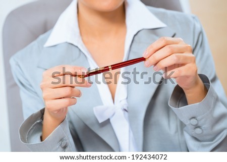 close-up of hands of a business woman, holding a red pen