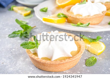 Lemon tartlets, Homemade shortbread mini tart cakes with lemon curd and whipped cream,white grey concrete background copy space