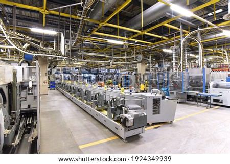 paper rolls and offset printing machines in a large print shop for production of newspapers and magazines
