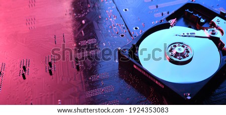 Computer Hard disk drives HDD , SSD on circuit board ,motherboard background. Close-up. With red-blue lighting. Royalty-Free Stock Photo #1924353083