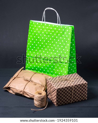 Recyclable and colourful white dotted pattern
paper bag for purchases, gifts and takeaway food, still life and mock up on black background. Environmentally friendly than single-use plastic bags