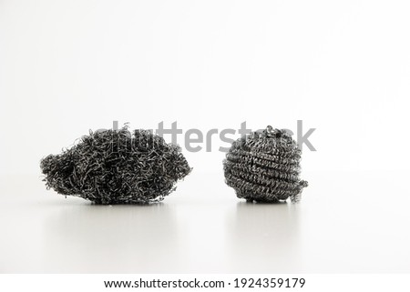 One used and one new kitchen metal wire sponges close up studio shot isolated on white.