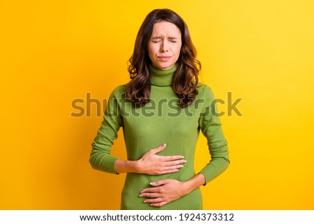 Photo of young unhappy unwell sick ill woman hold hand on stomach suffers pain pms isolated on yellow color background Royalty-Free Stock Photo #1924373312