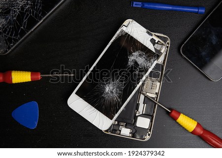 Screen cracked smartphone. Mobile phone with damaged touchscreen. Repairing smartphone. Replacing broken screen.