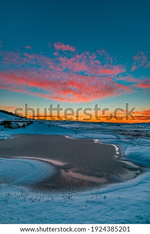A frozen lake and majestic sky during sunset