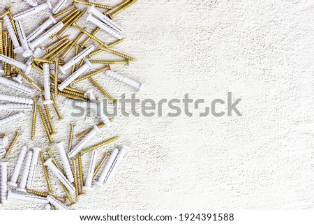 Many steel and plastic dowels for repairing on light gray cement background with copy space. DIY, Home improvement and house building concept