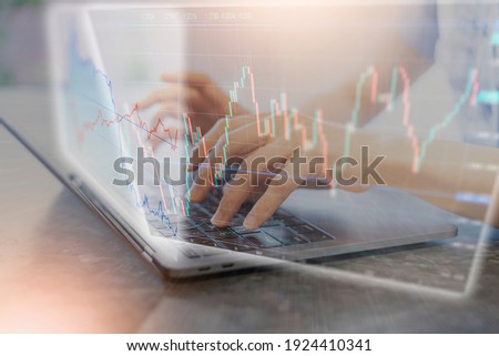 A composite photo of a female hand operating a notebook PC and a stock chart  Royalty-Free Stock Photo #1924410341