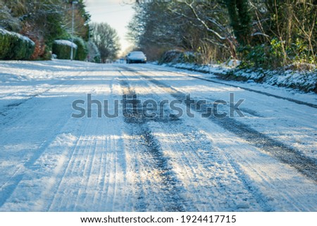 empty road covered with winter snow in england uk.